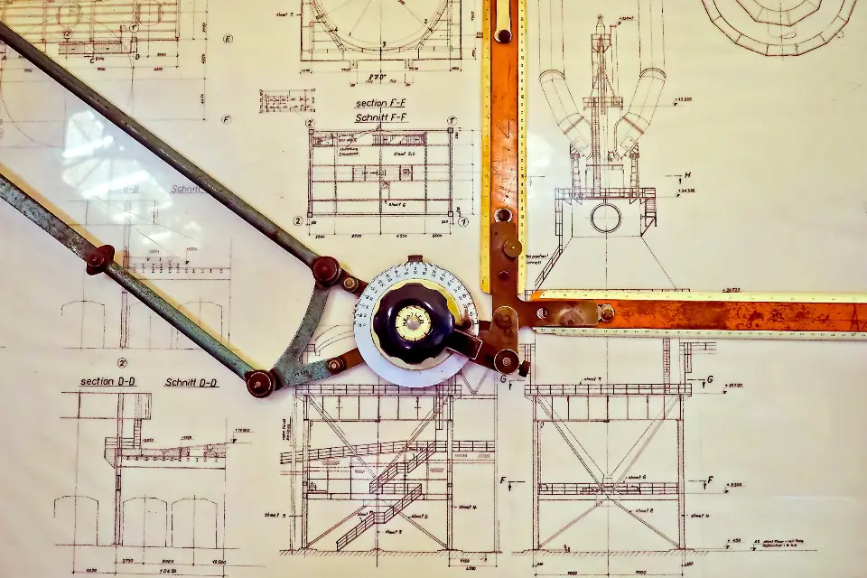 Technical drawings on a drafting table with a drafting machine