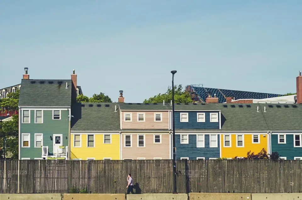 A row of colorful houses behind a long wooden fence